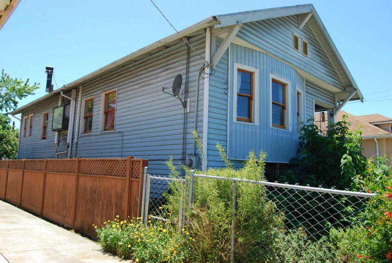 an old house behind a fence and yard