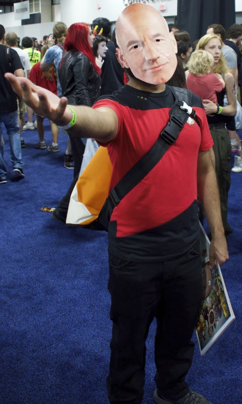 a man in a weird mask poses on the carpet