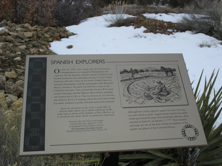 the spanish explore sign near some rocks and vegetation