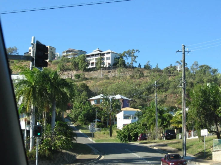 the street view from inside a vehicle, with a car parked at the side