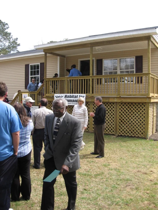 four people standing in front of a house