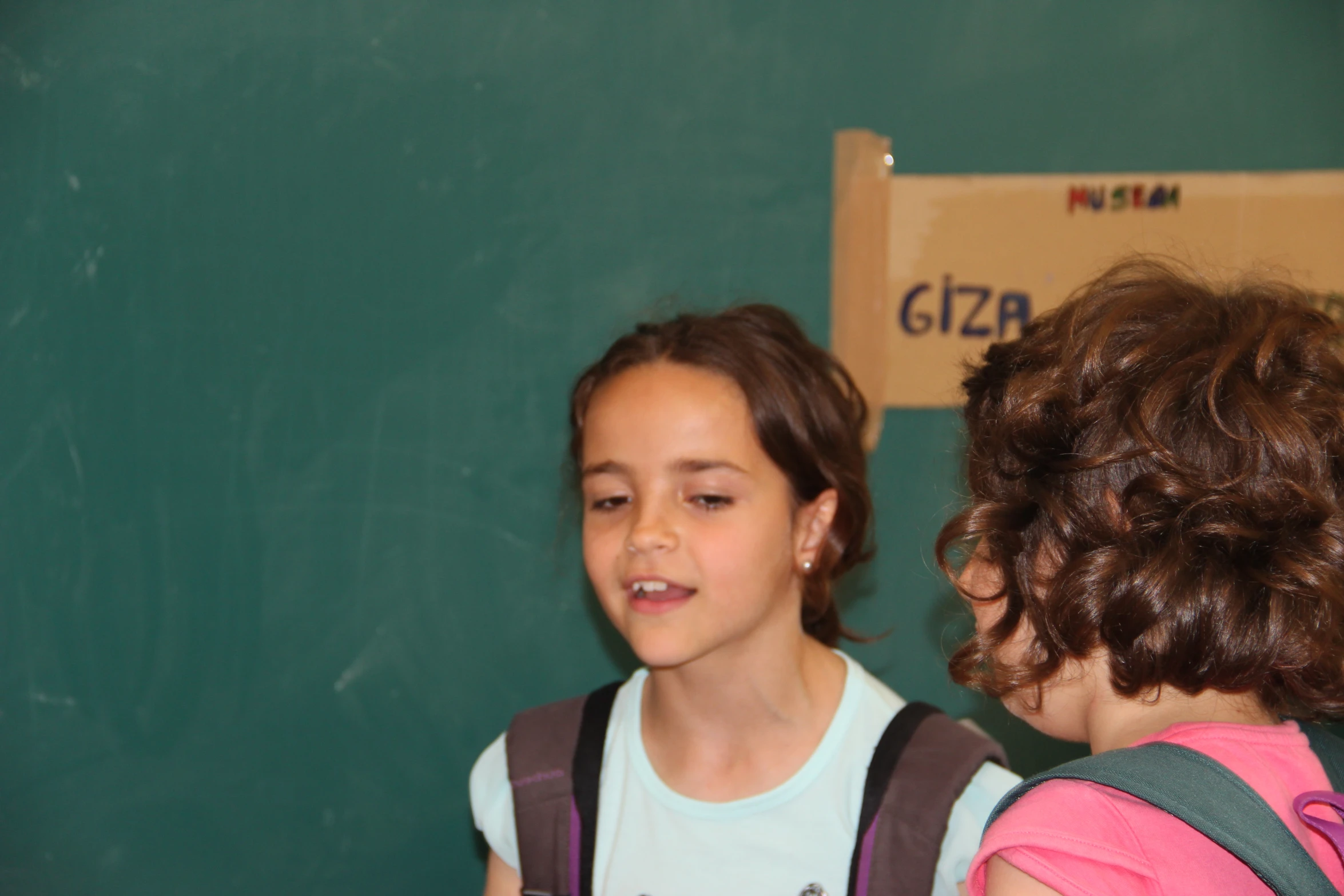 girl with backpack and back pack being watched by another