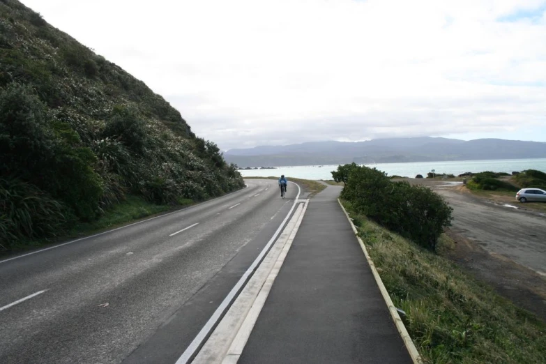 an empty roadway with people walking on the side