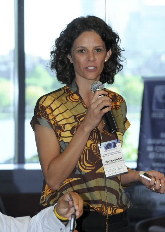 a woman standing behind a microphone in an office