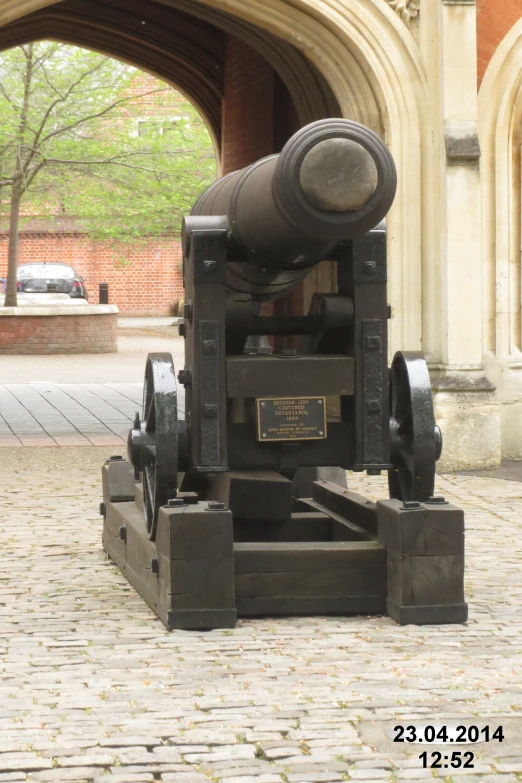 an old cannon standing in front of a big building