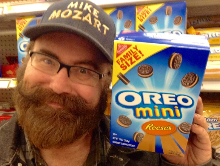 a man with glasses and beard is holding up a cereal box
