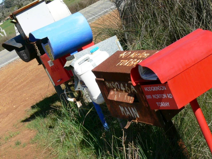 several mailboxes sit in the grass by the street