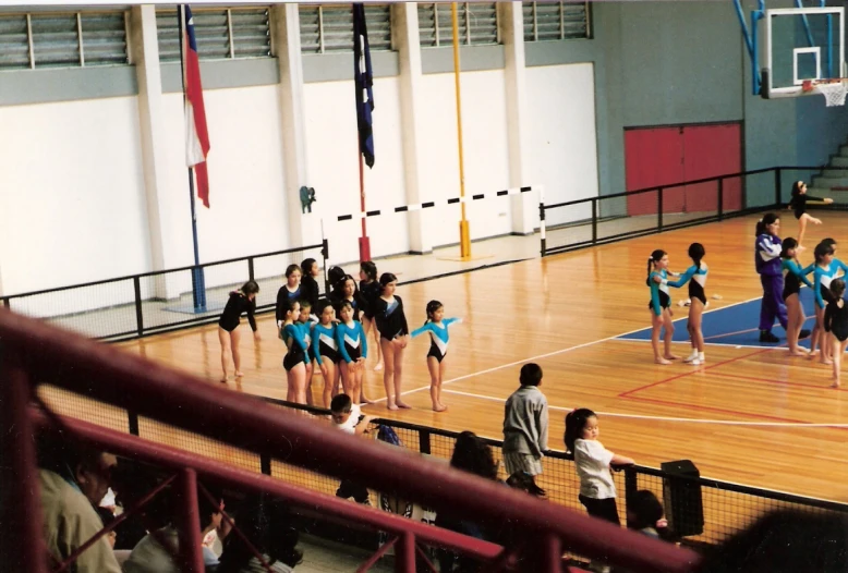 girls dressed in blue are standing on the court