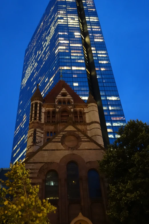 a tall tower with lights reflecting off it's side