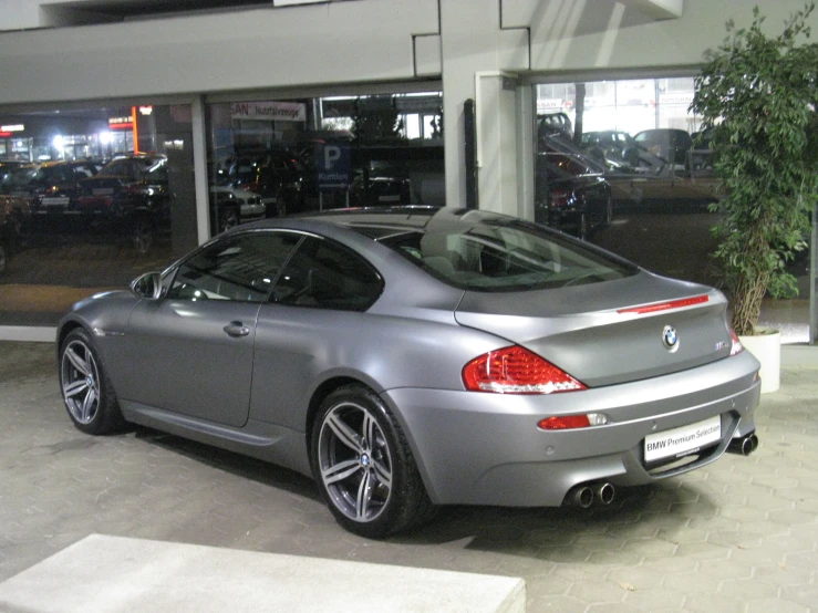 a grey bmw car sitting in a garage