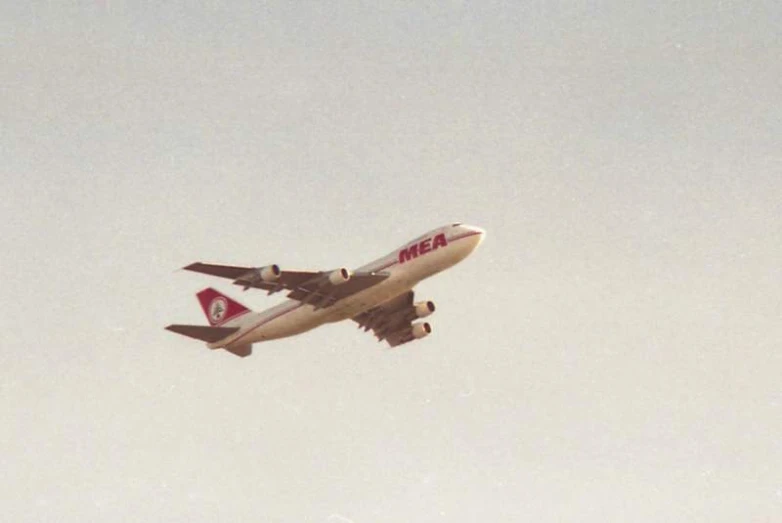 a passenger jet in the sky flying against a grey background