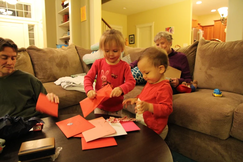 two children play with pieces of folded paper and scissors