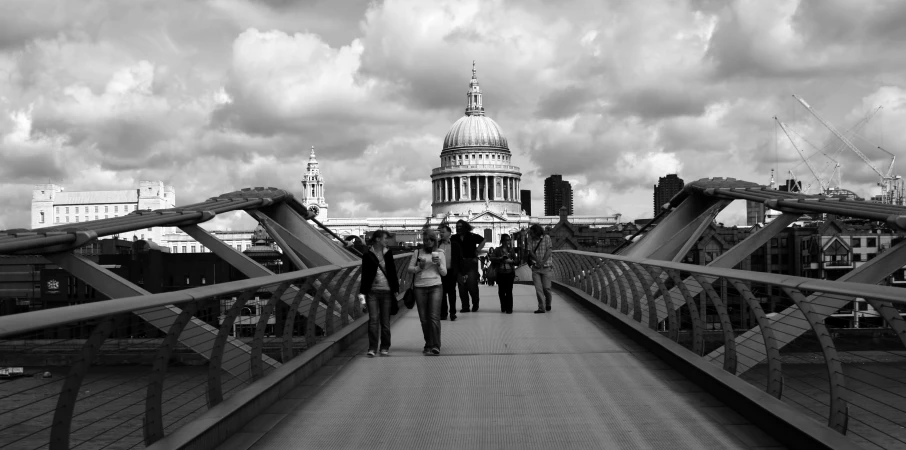 a group of people on a bridge that has buildings in the background