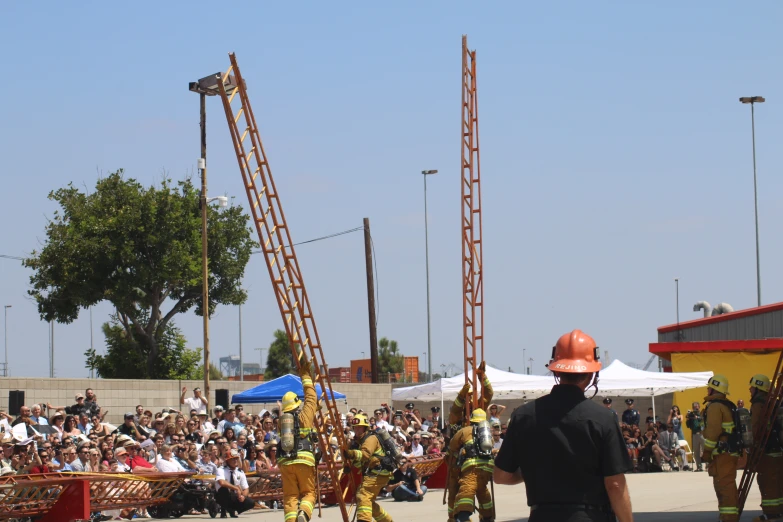 some construction workers standing near a large fire escape ladder