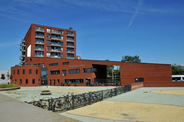 the building is red brick and has many balconies on its sides