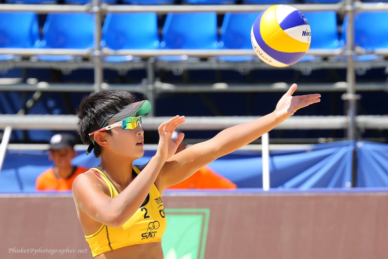 there is a woman throwing a volleyball and another woman looking on