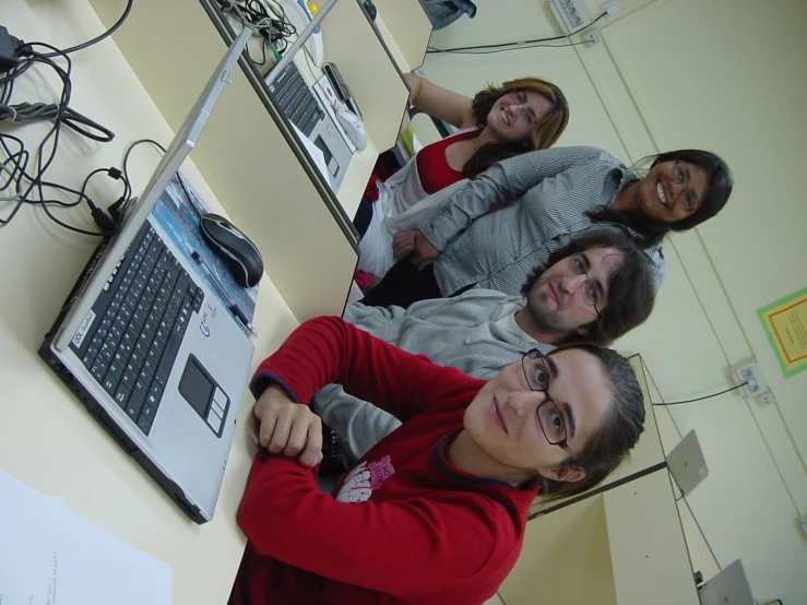 a family pose for a po in front of a laptop computer