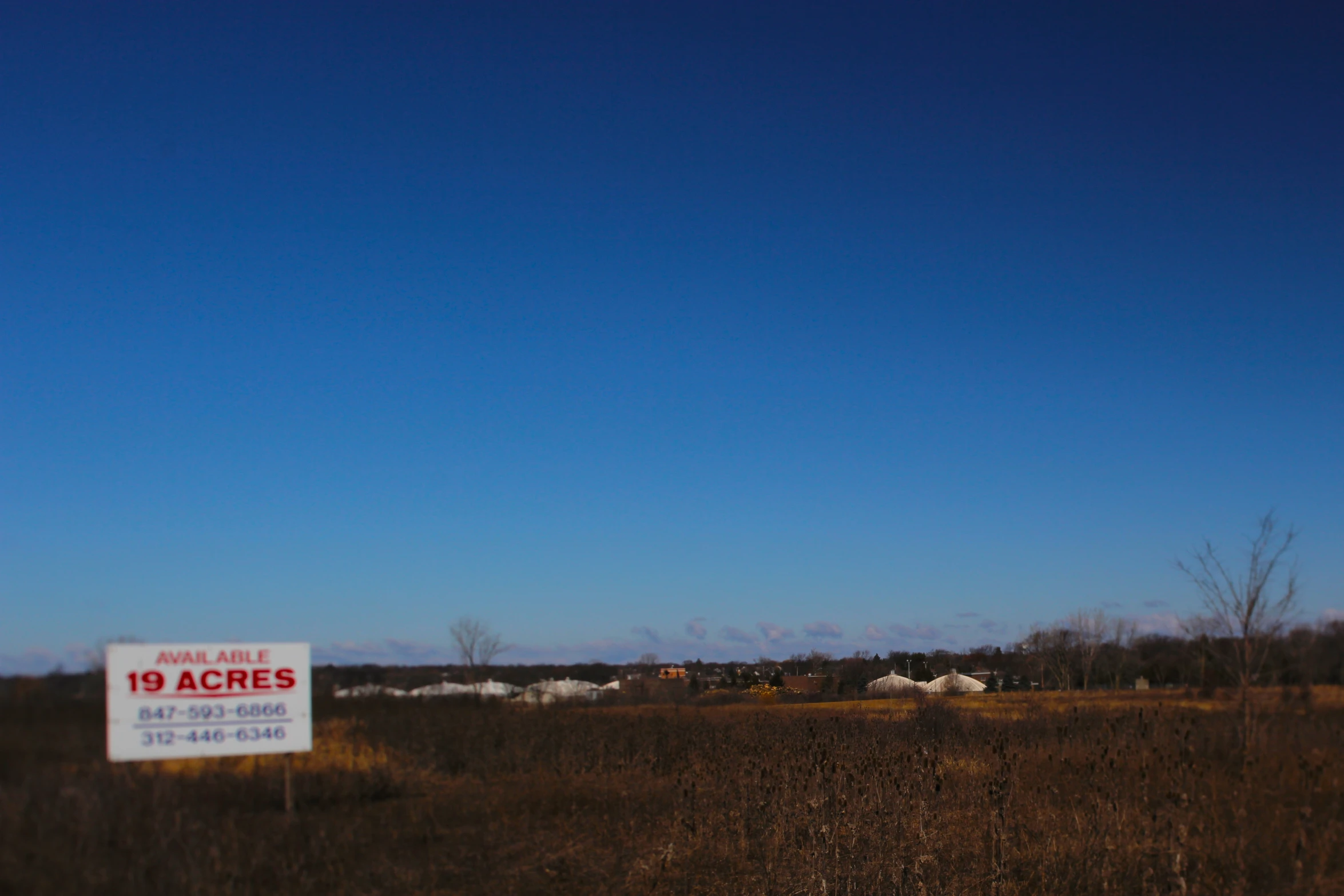 a field with a sign in the foreground