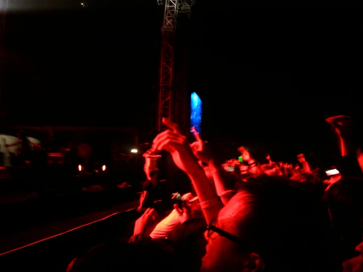 crowd of people at event raising their hands up in the air