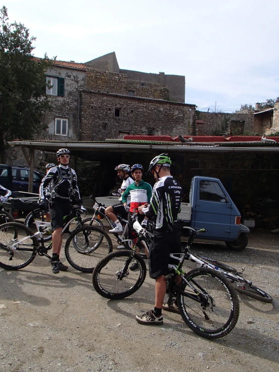 a group of people standing next to each other near parked bikes