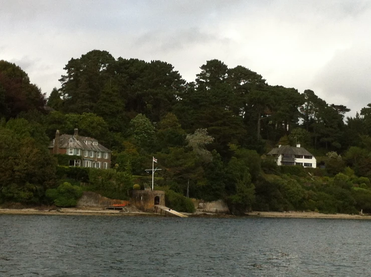 the house is on the hill above the water