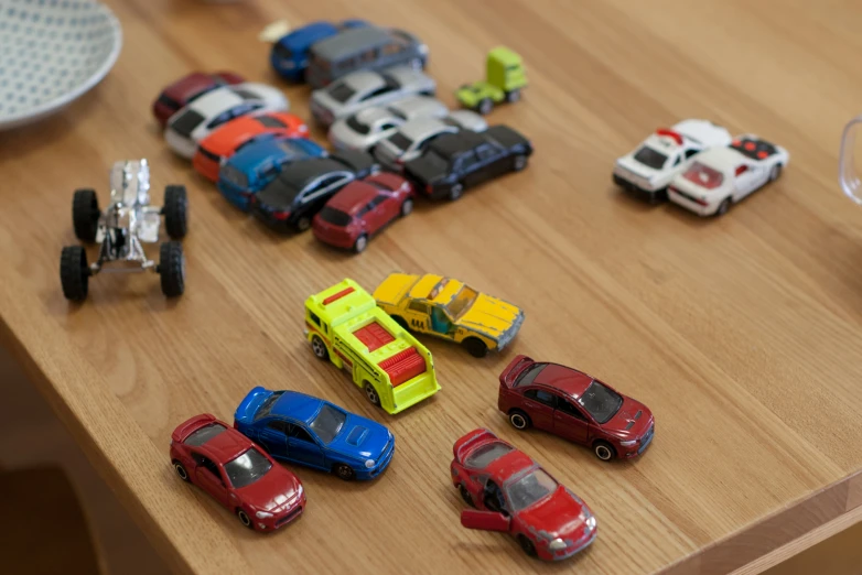 several different colorful model cars sitting on a table