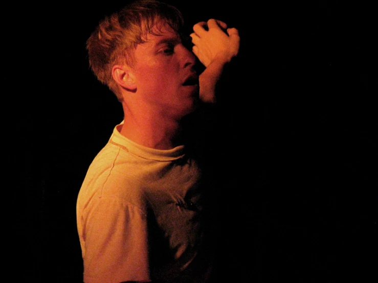 a young man in a yellow shirt holding a white frisbee in his right hand