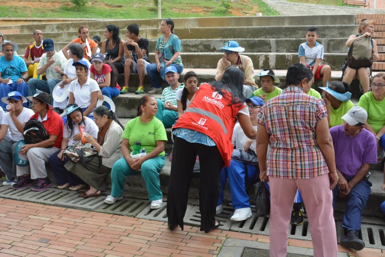 the many people are seated on the steps