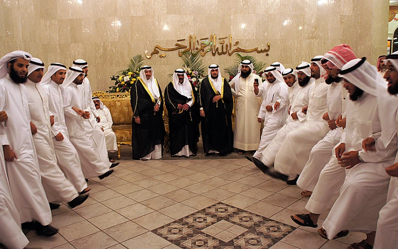 a group of men in white clothes stand behind each other