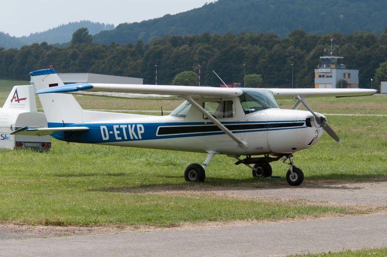 the small blue and white biplane is on the ground