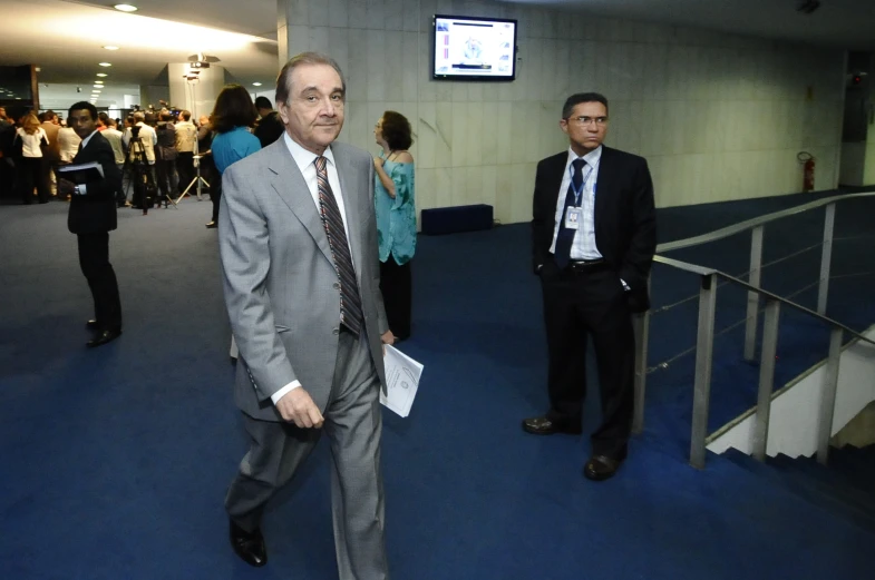 two men in suits walking through an office