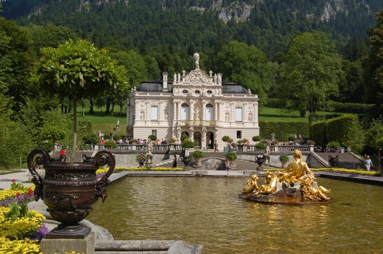 a very large pretty white building with flowers and a fountain