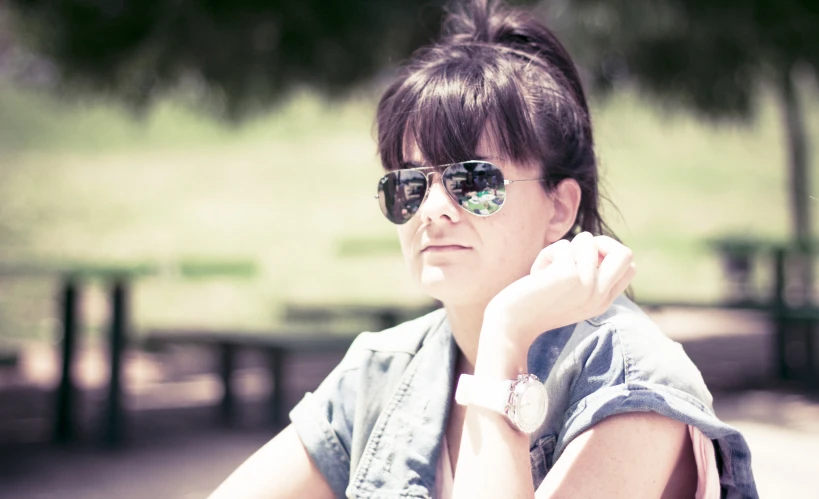 a women wearing glasses sits on a bench