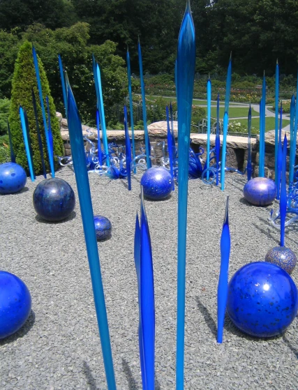 many blue sculpture sit on the ground and look like they have been blown up