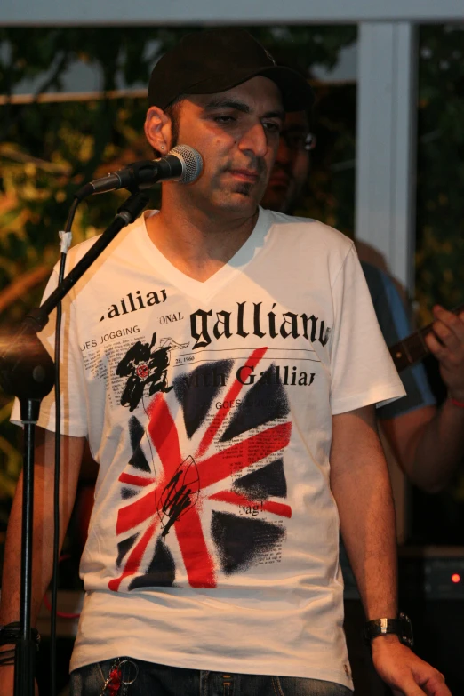 a man standing next to a microphone while wearing a t - shirt