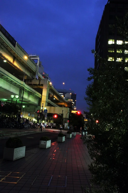 an empty city sidewalk is at night, and the red light shows