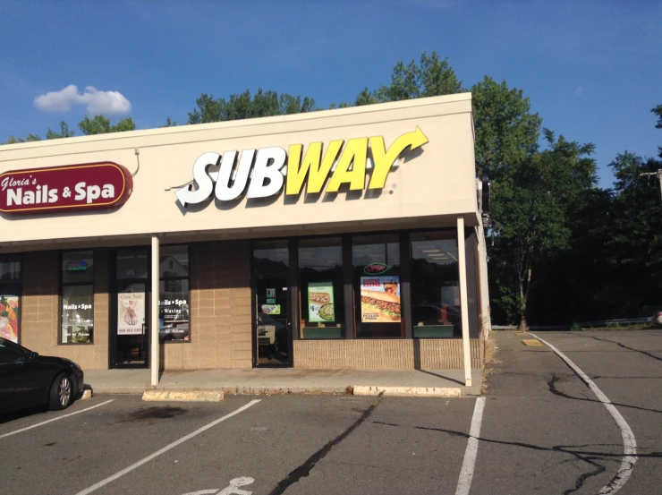 a subway with no doors and two cars parked in the lot