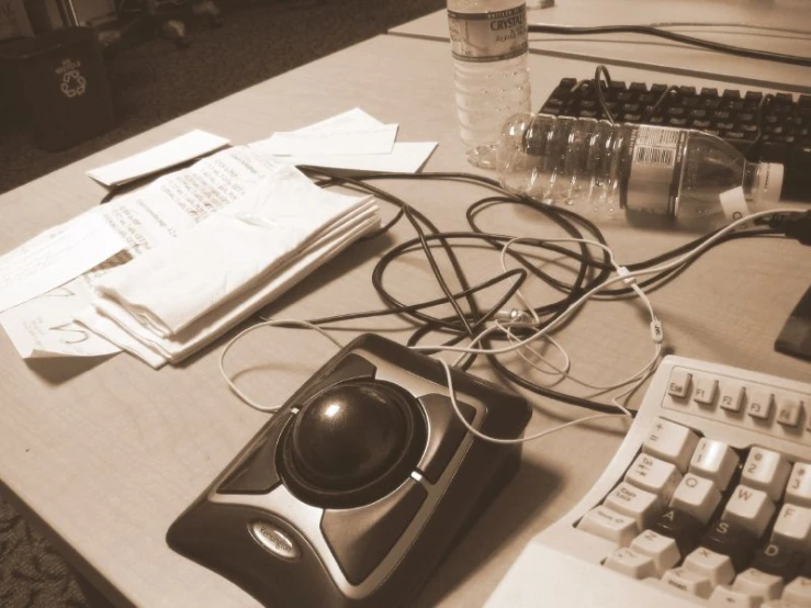 a desk with a keyboard, monitor and telephone with a notepad