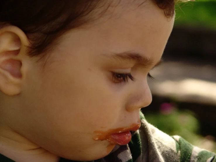 a close up of a child with a piece of food in his mouth