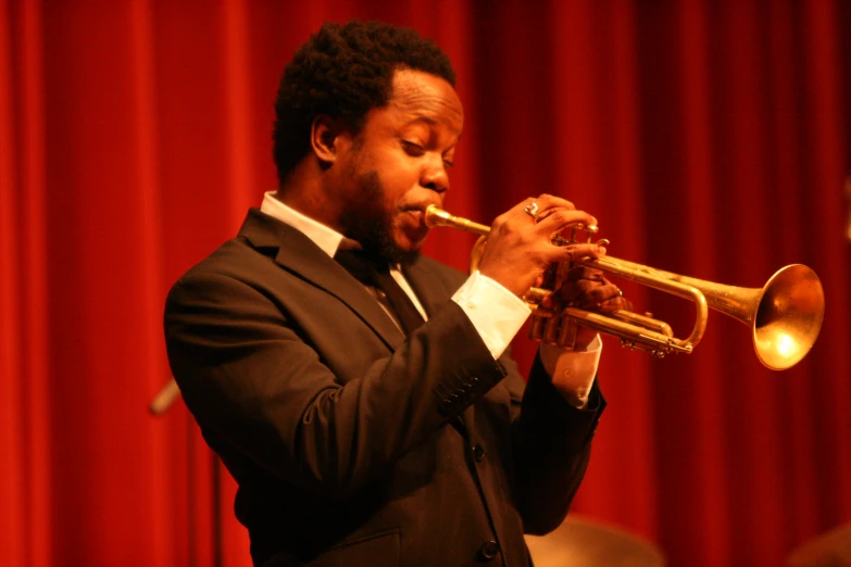 a man playing the trumpet while wearing a suit