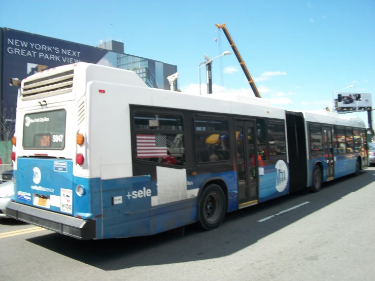 a blue and white bus driving down a street