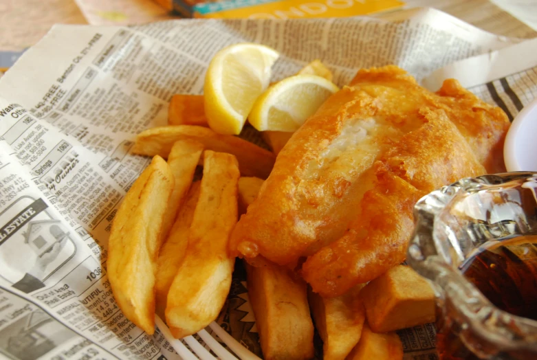 there is fish with a side of fries and a lemon wedge