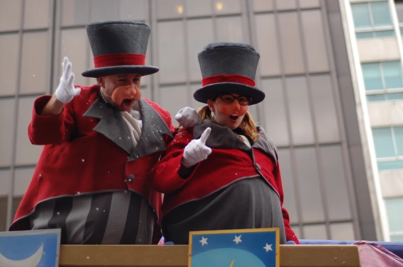 two performers in fancy attire standing on a float