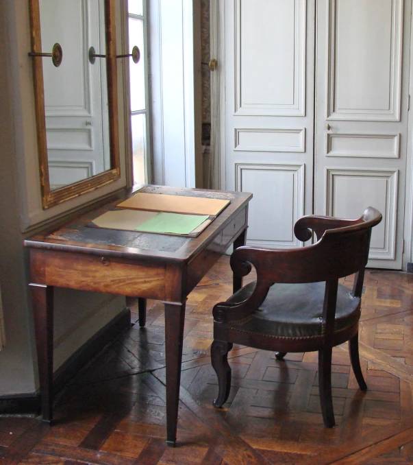 a desk and chair with an open book next to each other