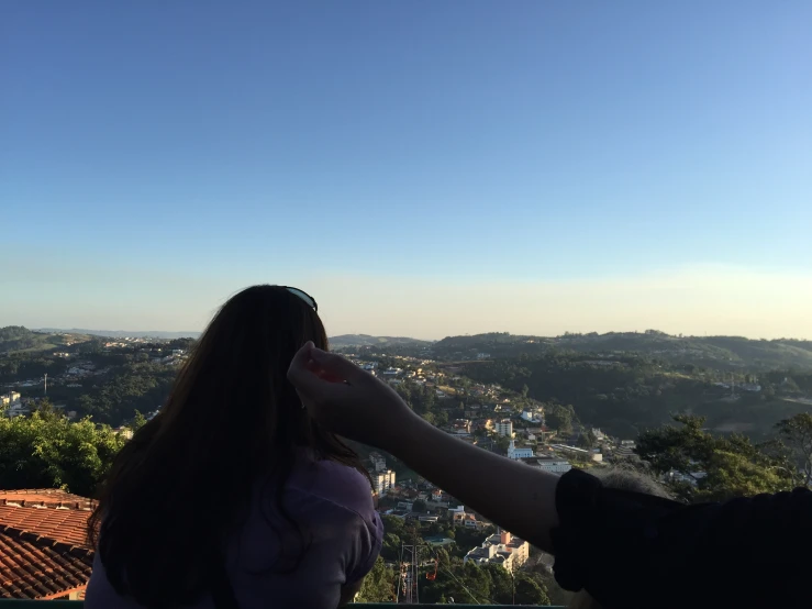 two people stand looking over a hilly area