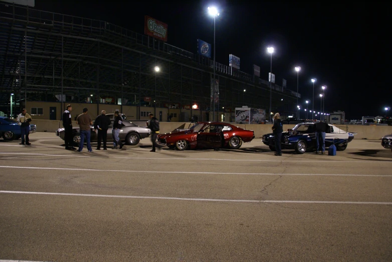 a group of people gather near a car that has been tipped over