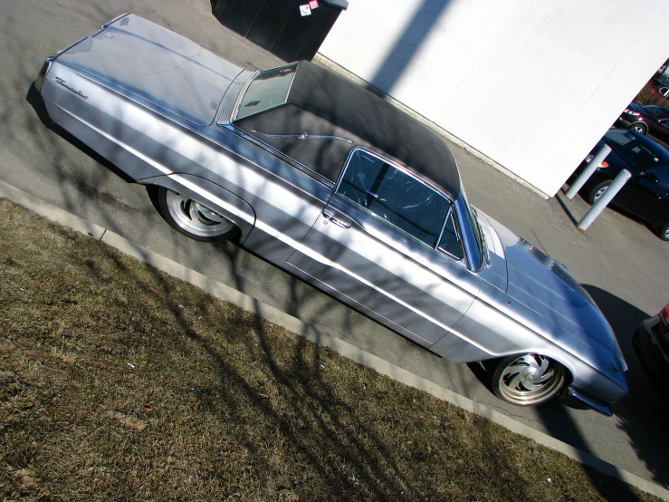 a silver car parked in a parking lot next to a building