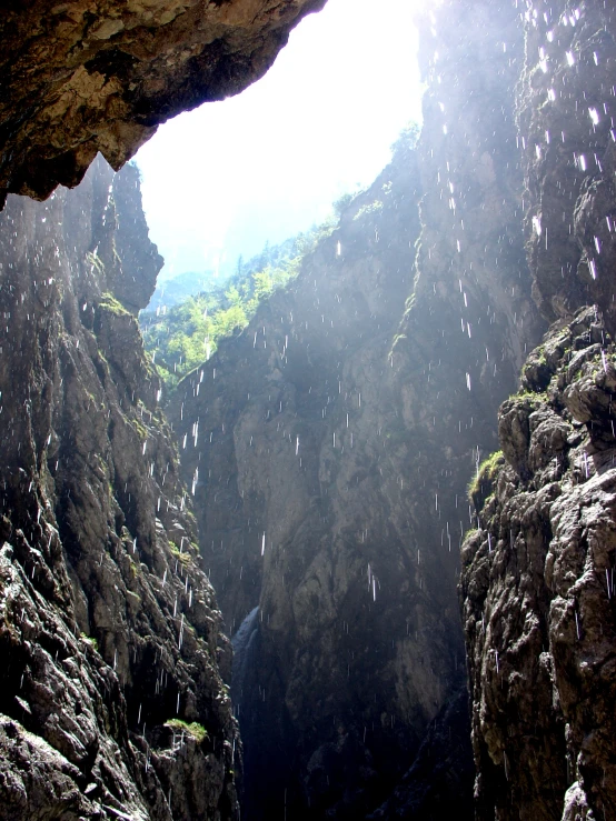 a cave with water flowing out the side