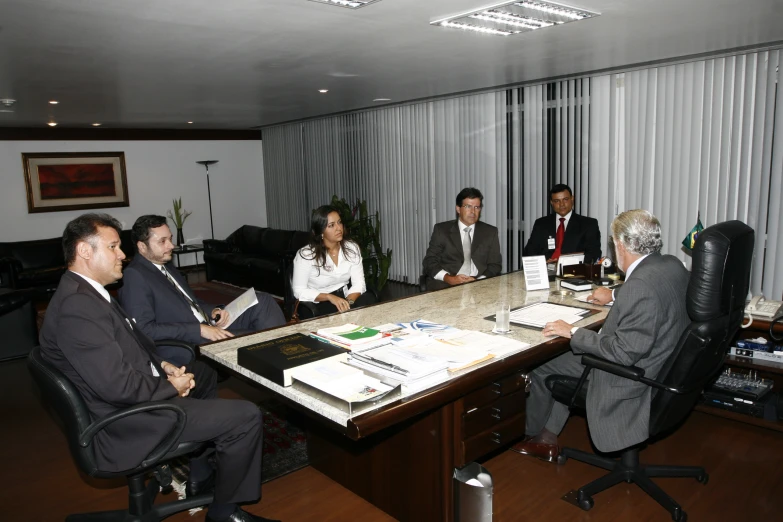 a group of people are sitting at a conference table