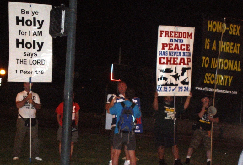 a group of people holding up protest signs at night